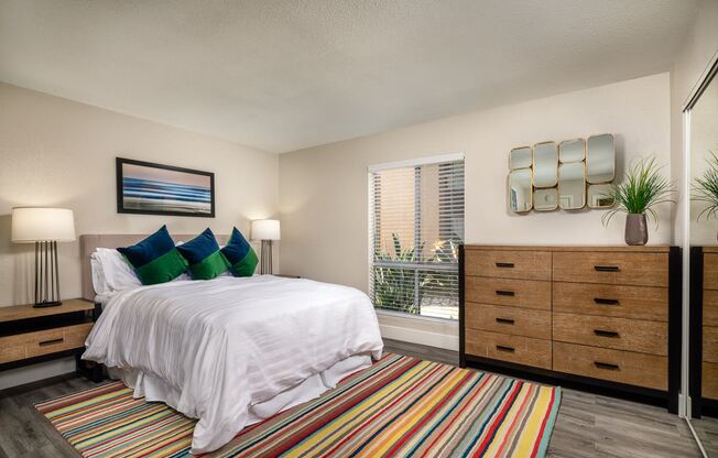 One Bedroom Apartments in Oceanside CA - Stone Arbor - Bedroom with Wood-Style Flooring, Mirrored Closets, and Large Window