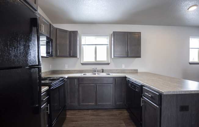 Modern open-concept kitchen and living area with black appliances.