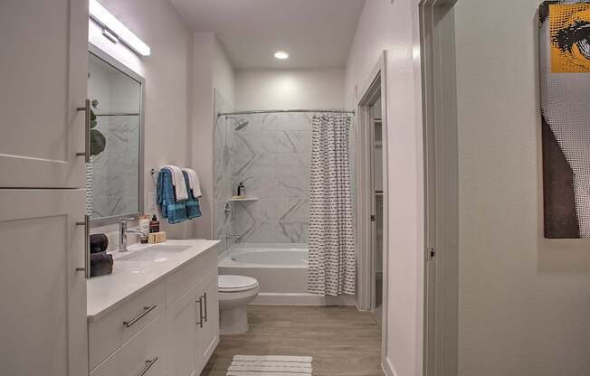 A bathroom with a white counter and a white toilet.