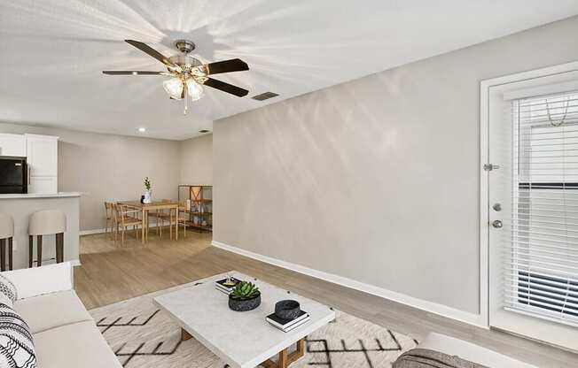Model Living Room with Wood-Style Flooring and Patio Accessibility at Huntington Place Apartments located in Sarasota, FL.