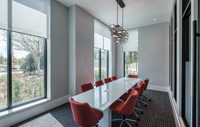a conference room with a long white table and red chairs at Altis Grand Suncoast, Florida, 34638