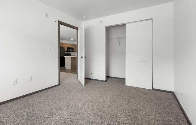 A room with a carpeted floor and two white doors.