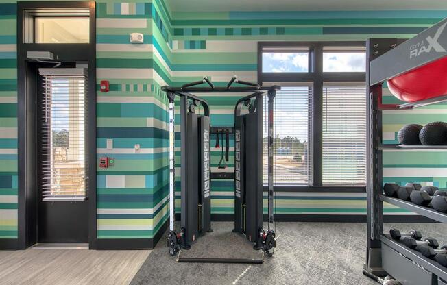 a gym with green and white striped walls and gym equipment
