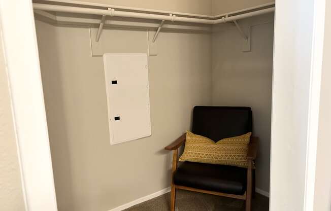 a chair in a small room with a white hanger on the wall