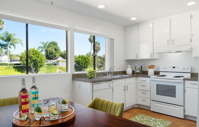a kitchen with white cabinets and a wooden table