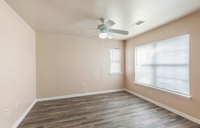 Living room with ceiling fan and windows and blinds