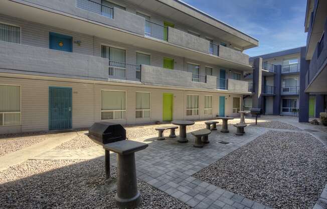 a courtyard of a building with benches and a grill