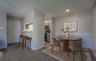 A dining room with a table and chairs.