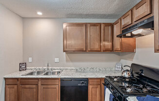 a kitchen with a stove top oven and a sink