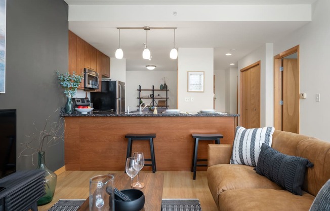 a living room with a couch and a kitchen with a bar