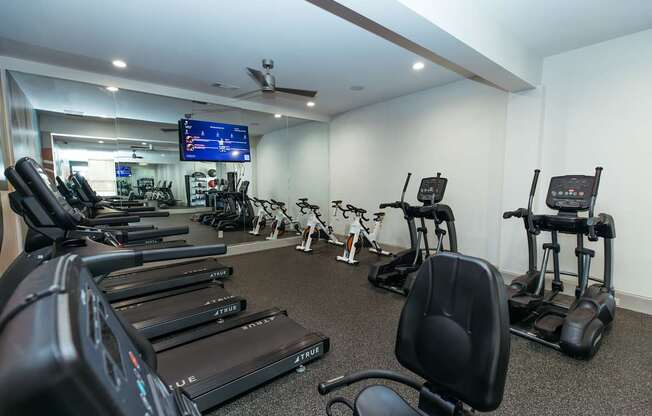 A gym with treadmills and elliptical machines.