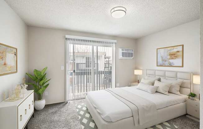 A bedroom with large sliding doors to a private balcony. Staged with a queen-size bed, 2 side tables, a dresser, and wall art.at Wildflower, Kennewick, 99336