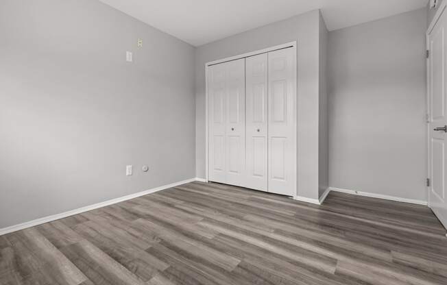 the living room of an apartment with white doors and wood flooring