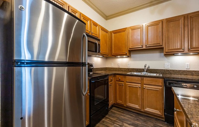 a kitchen with wooden cabinets and stainless steel appliances