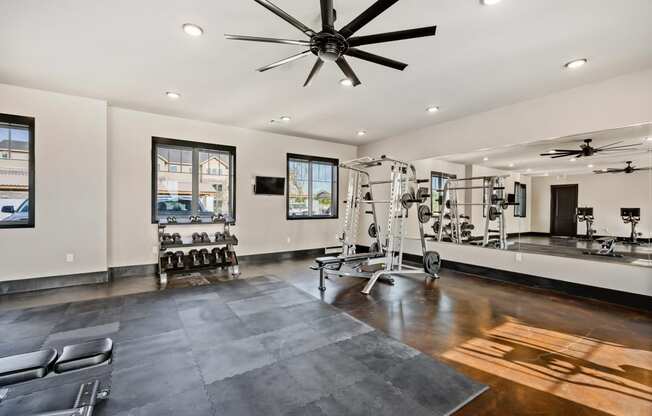 a home gym with a gym flooring and a ceiling fan