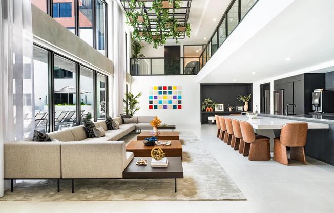 Poolside clubroom with communal seating, a demonstration kitchen, and suspended greenery creating an inviting break from the Coral Springs sun.