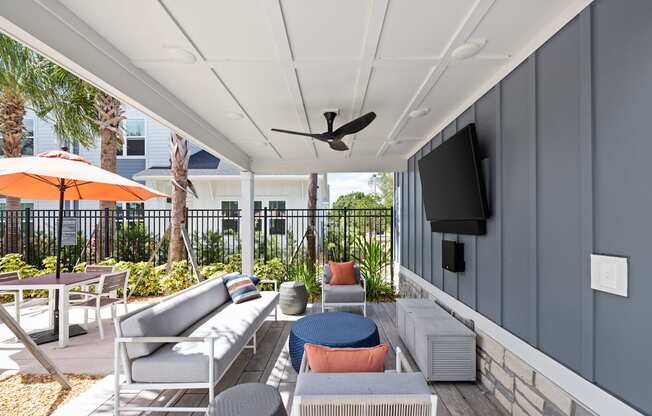 a patio with couches and chairs and a tv on the wall at The Sophia, Venice, FL, 34275