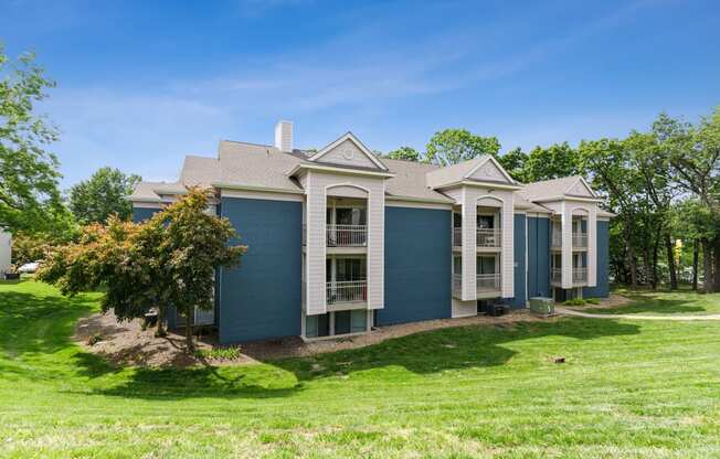 a blue house with white trim and a green lawn at Eastwood Crossings, Missouri, 64129