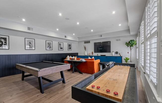 a game room with a shuffleboard table and a pool table