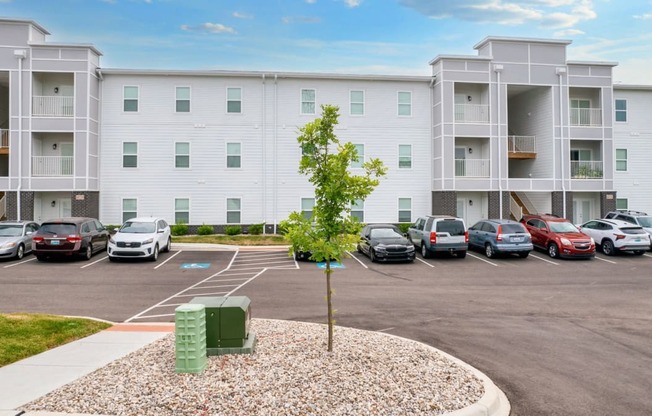 an empty parking lot with cars in front of an apartment building