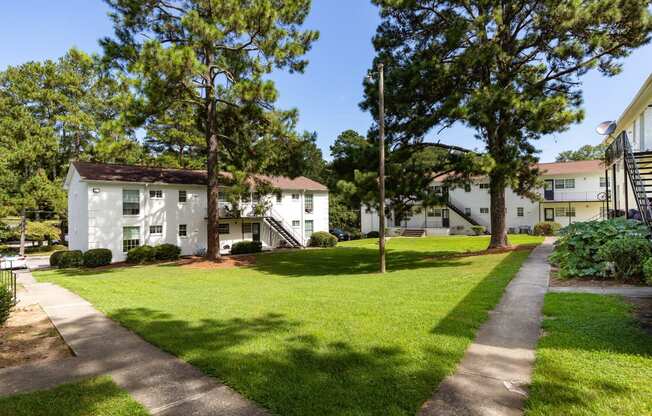 exterior view of apartments with a lawn and trees