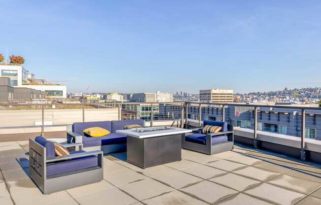 a terrace with couches and a table on a roof overlooking the city