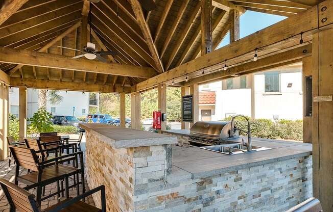 Outdoor grilling pavilion with bar counter seating at Two Addison Place Apartments , Pooler, GA