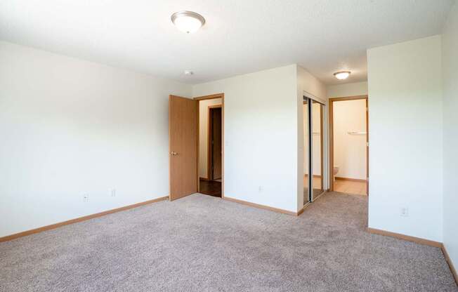 A room with a carpeted floor and a ceiling light. Bismarck, ND Sierra Ridge Apartments