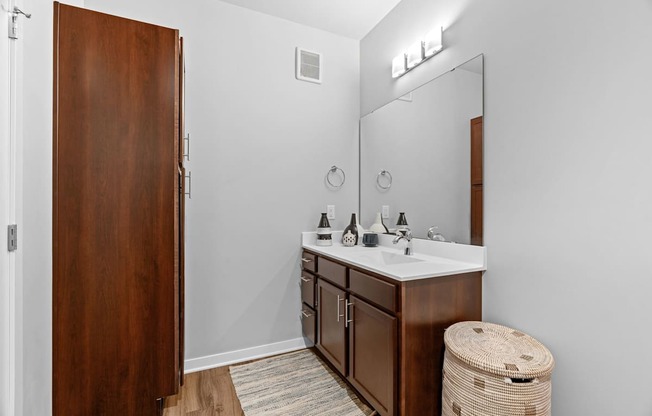 A bathroom with a wooden door and a white sink.