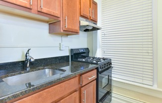 kitchen with granite countertops, tile backsplash and large windows at dupont apartments in washington dc