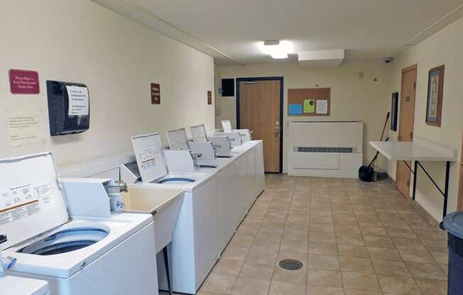 a washer and dryer room with a row of washing machines