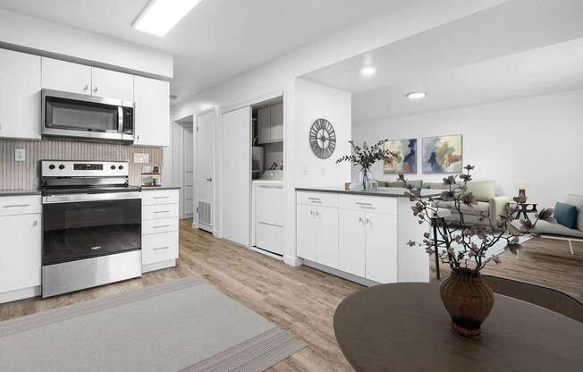 A modern kitchen with white cabinets and stainless steel appliances.