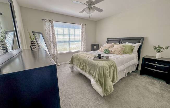 a bedroom with a bed and a ceiling fan