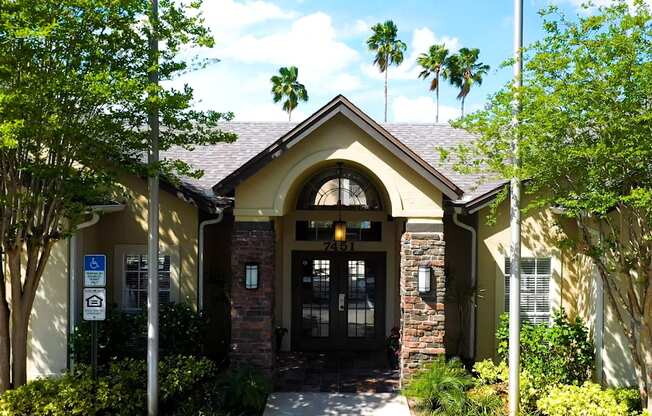 A building with a black door and windows surrounded by trees.