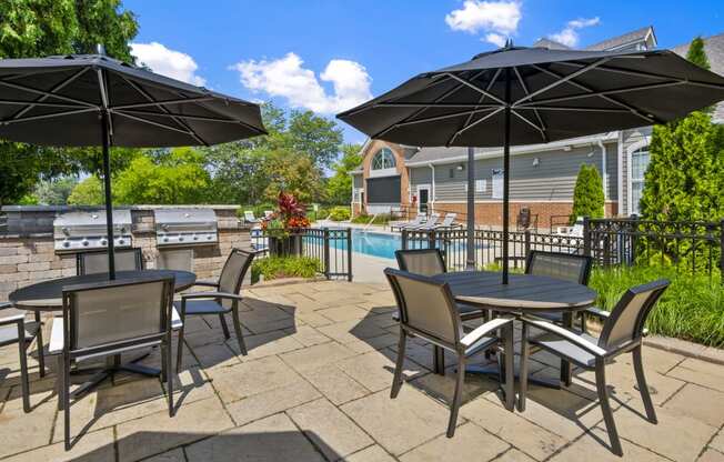 Patio Table, chairs, and umbrellas by a pool