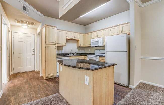 Vacant apartment at Cypress Lake at Stonebriar in Frisco, TX has kitchens with golden oak cabinets and whit eappliances!