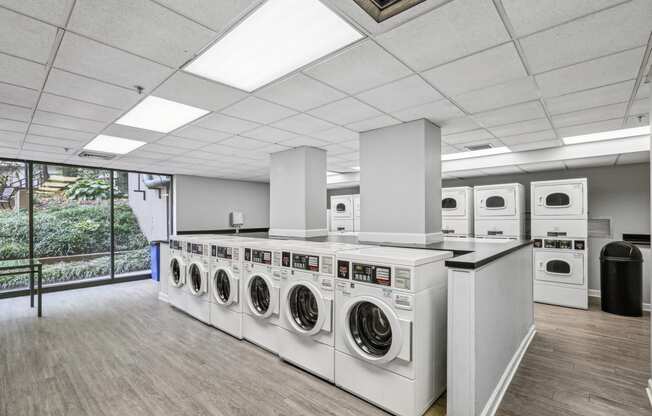 a laundry room with washers and dryers and a row of washing machines