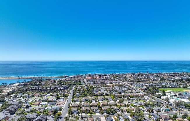 an aerial view of a city with the ocean in the background