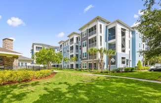 Our large luxury apartment buildings with a green lawn in front of it at Dunedin Commons apartments in Dunedin, FL