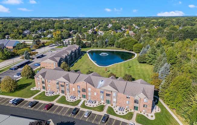 Exterior apartment buildings with a pond in back of it at Oak Shores Apartments in Oak Creek, WI