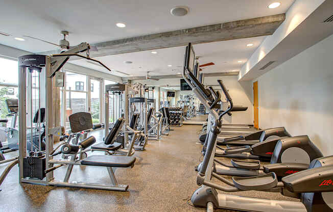 A gym with treadmills, weights, and exercise equipment.