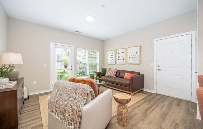 A living room with a couch, a chair, a table, and a lamp.
