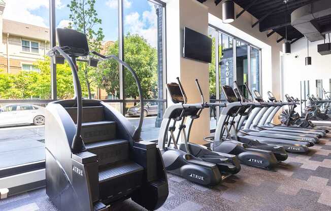 A gym with a variety of cardio equipment including treadmills and elliptical machines.