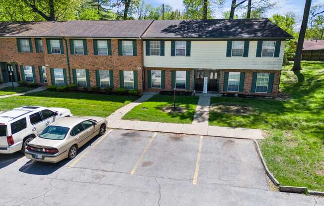 a large brick house with cars parked in front of it