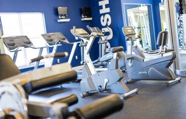 A gym with a row of exercise bikes.