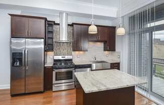 a kitchen with stainless steel appliances and a marble counter top