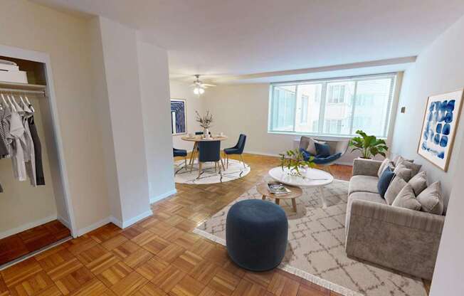 A well-lit, spacious living room with a wooden floor and a large window.