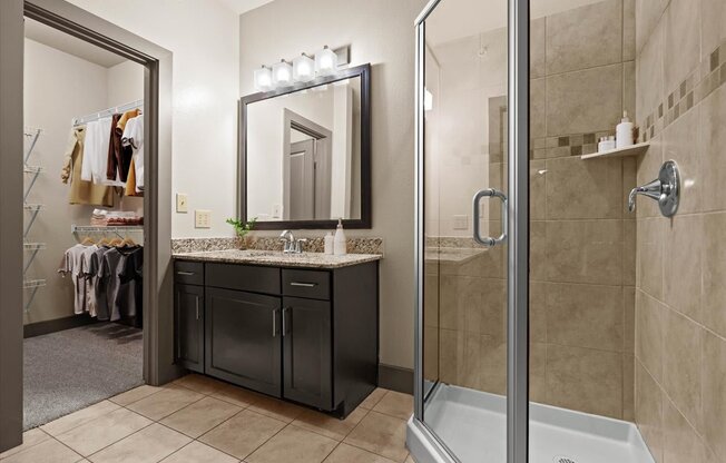 a bathroom with a shower stall sink and mirror