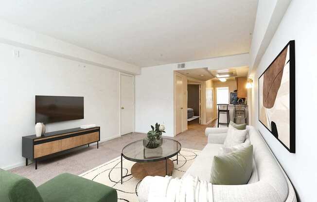A living room with a white couch, a green chair, and a glass coffee table.