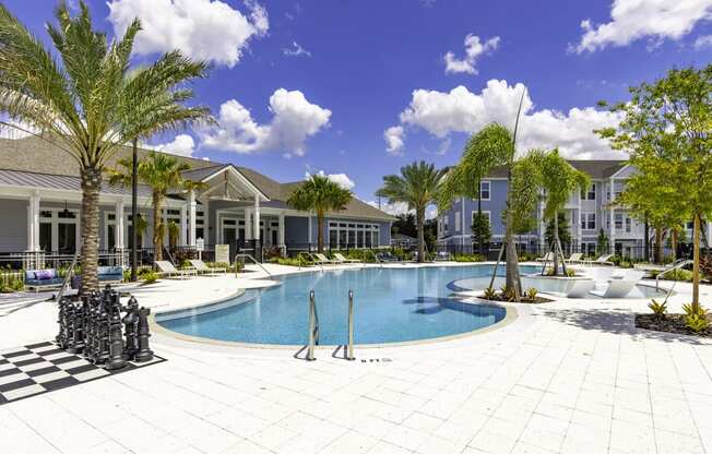 a large swimming pool in front of a building with palm trees